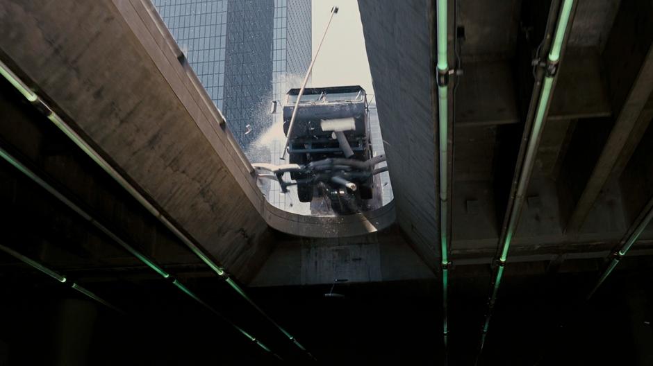 The bomb truck crashes through a barrier and falls to the street below.