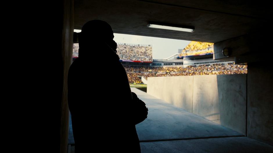 Bane stands and waits for the explosions to begin.