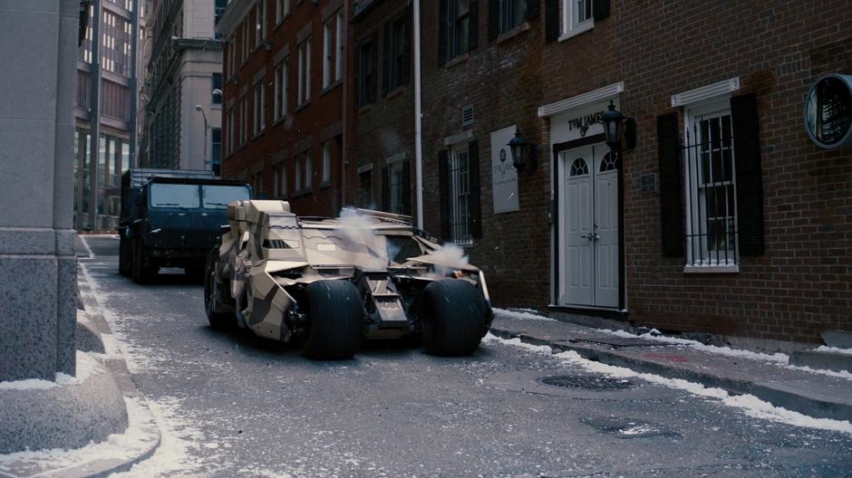 The tumbler is fired upon by the technical while the bomb truck follows behind.