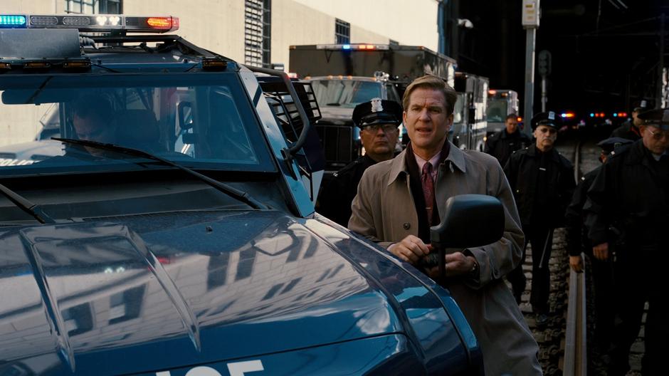 Foley waits outside the tunnel while the police search for Bane's hideout.