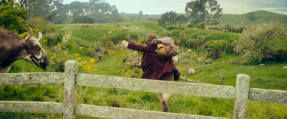 Bilbo runs through Hobbiton while trying to catch up with the dwarves.