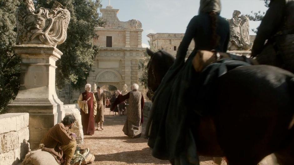 Catelyn and Ser Rodrik ride towards the gate.