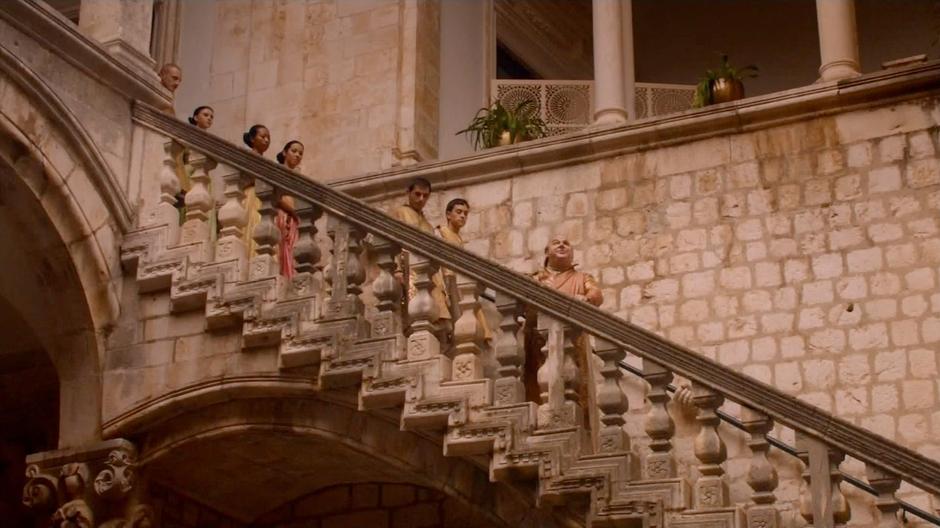 The Spice King stands on the stairs with his retinue while talking to Daenerys.