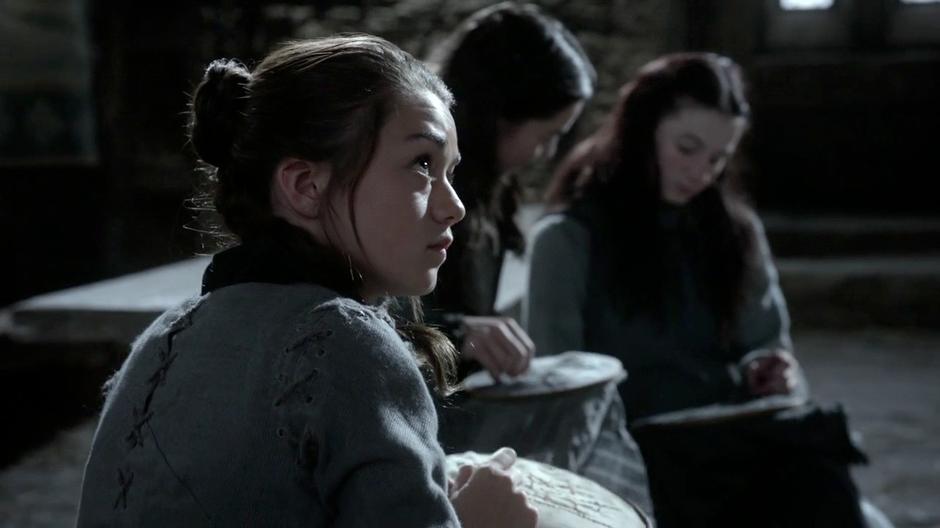 Arya is distracted while attempting her needlework.