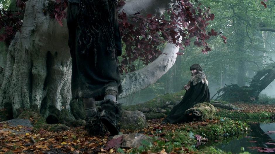 Osha walks up to Bran who is praying by the Weirwood tree.