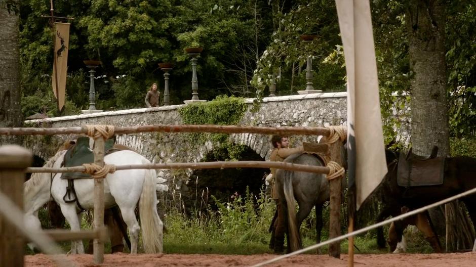 Ned Stark walks across the bridge to the empty tournament grounds.