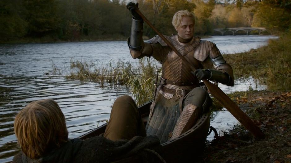 Brienne pushes the boat away from shore.