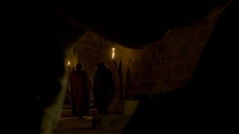 Varys and Illyrio walk up the stairs after passing Arya.