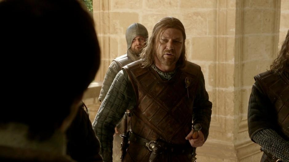 Ned approaches the messenger who is held by his guards.