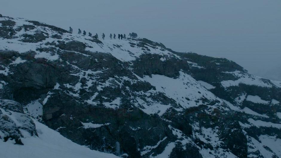 Jon Snow and the Halfhand are escorted across the top of a ridge.
