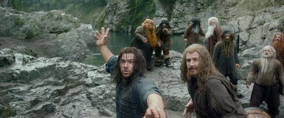 The dwarves react after Bard shoots a stone out of Kili's hand.