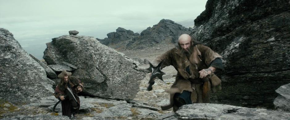 Dwalin and Nori struggle up a slope.