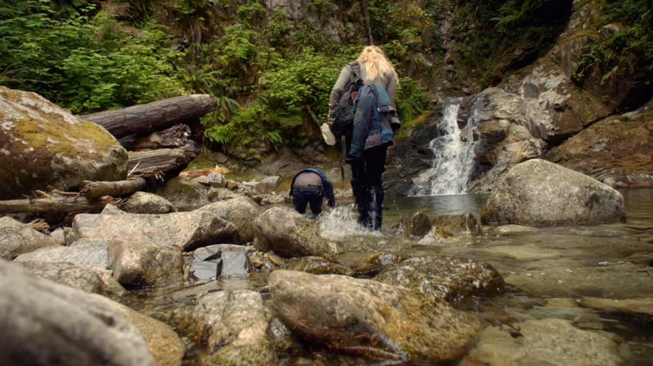 Finn wades in the pool while Clarke collects water.