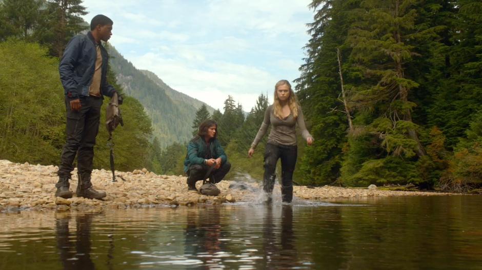 While Finn and Wells are trying to figure out how to recover the plants without getting wet, Clarke wades into the river.