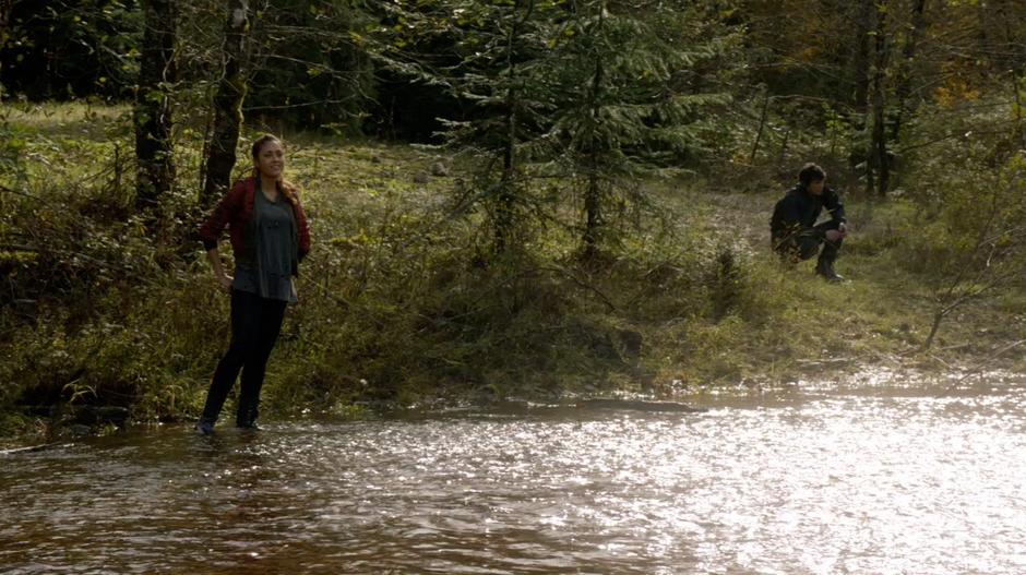 Raven is exasperated and Bellamy crouches by the river side.