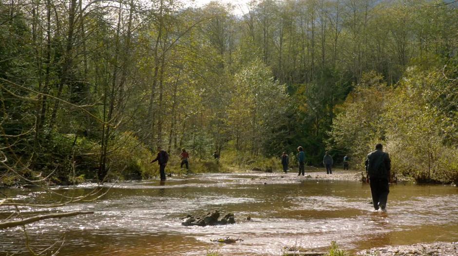 A bunch of people search the river for the lost radio.