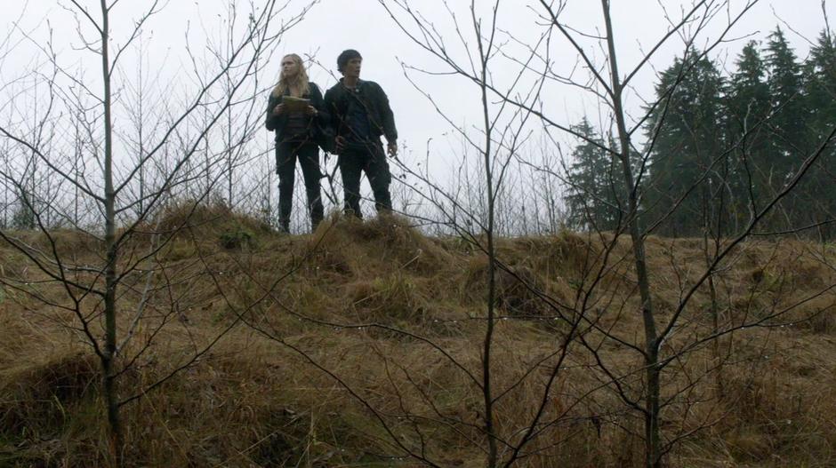 Clarke and Bellamy look down at the flooded buildings.
