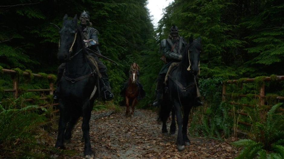 The Grounder leader Anya rides up with her two guards.