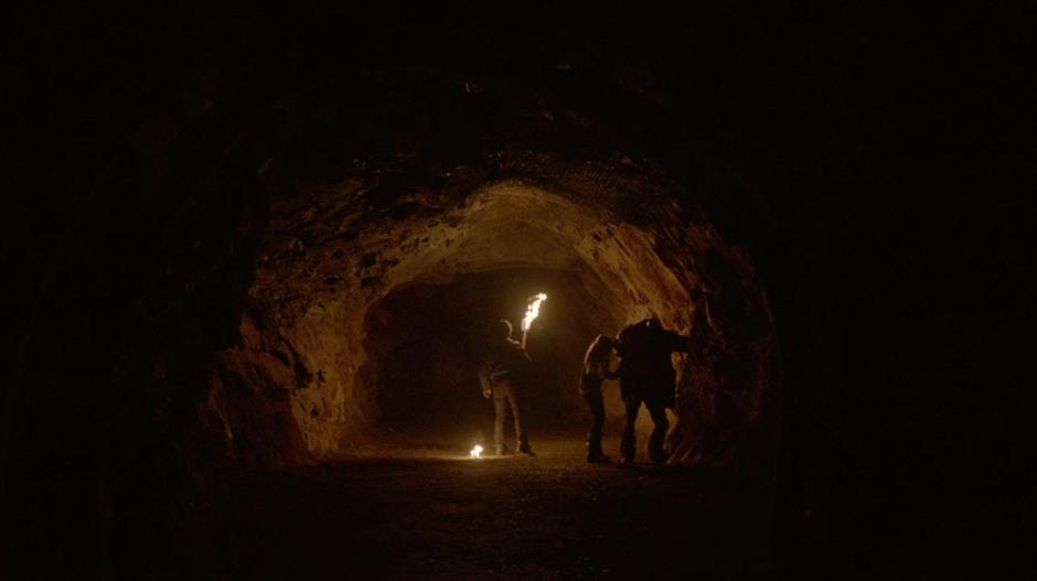 Clarke checks on Lincoln's wound while Finn watches down the tunnel.