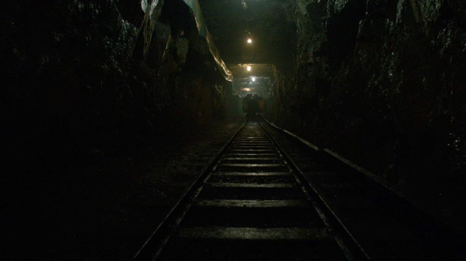 A reaper pushes a cart containing Clarke and Anya down the tunnel.