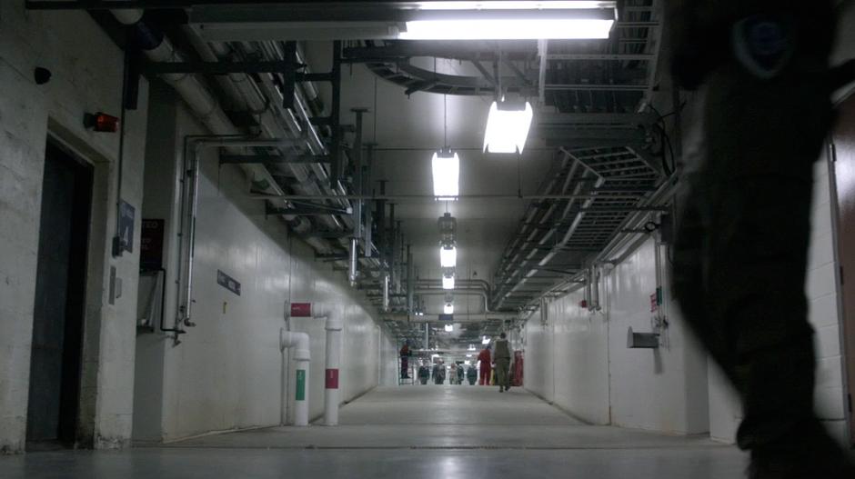 Clarke and President Wallace walk down a long hallway to the elevator.