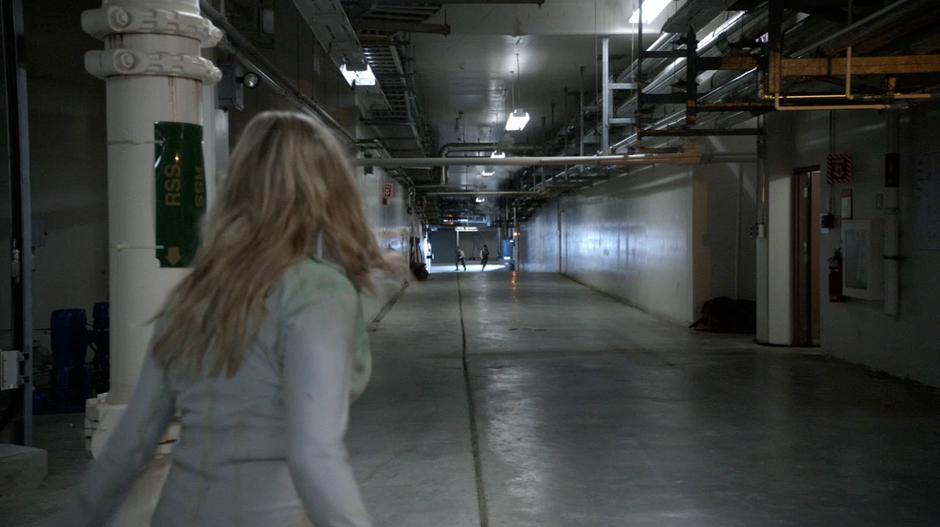 Clarke sees two guards coming up the hallway to catch her.