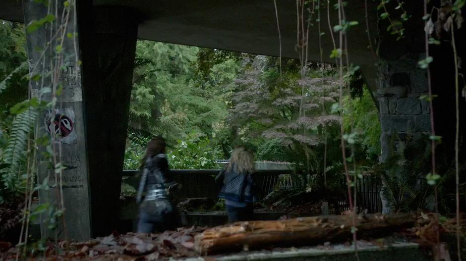 Lexa and Clarke run through the zoo away from the creature.