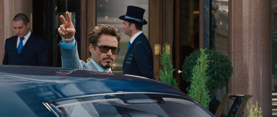 Tony Stark flips the peace sign at the onlookers.