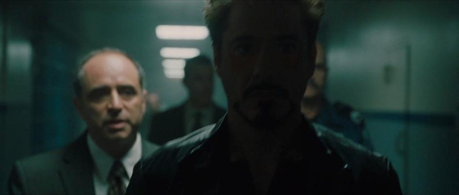 Tony Stark is escorted down the hall to Ivan Vanko's jail cell.