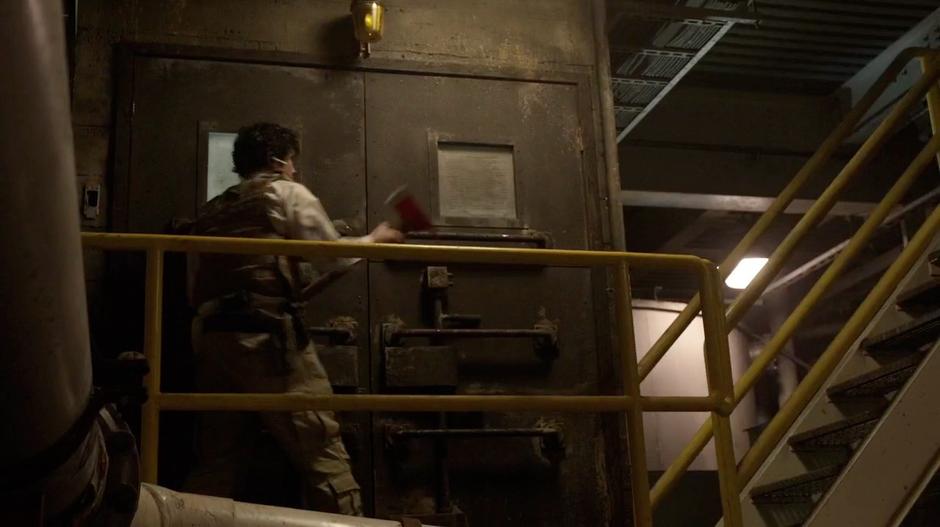 Bellamy uses the fire ax to block the door to the room.