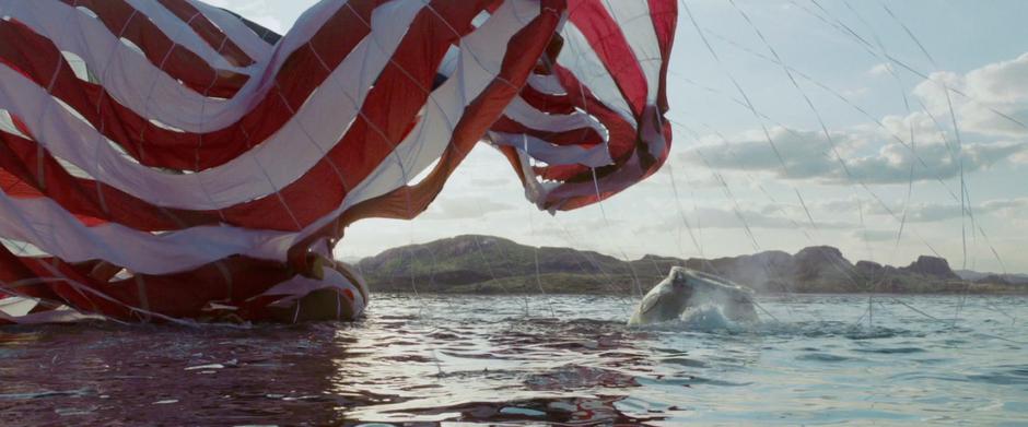 The parachutes from Dr. Stone's pod float down to the ground.