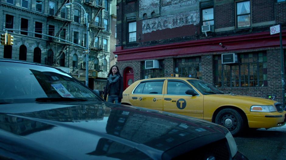 Jessica gets out of the taxi in front of the bar.