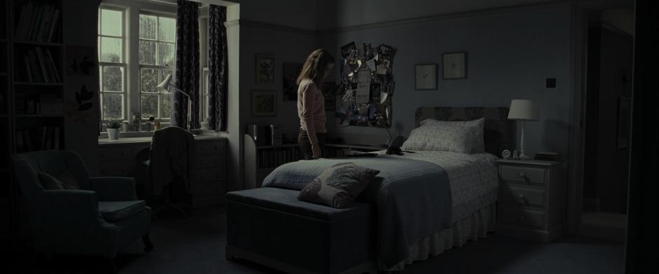 Hermione looks down at the newspaper on her bed in her room.