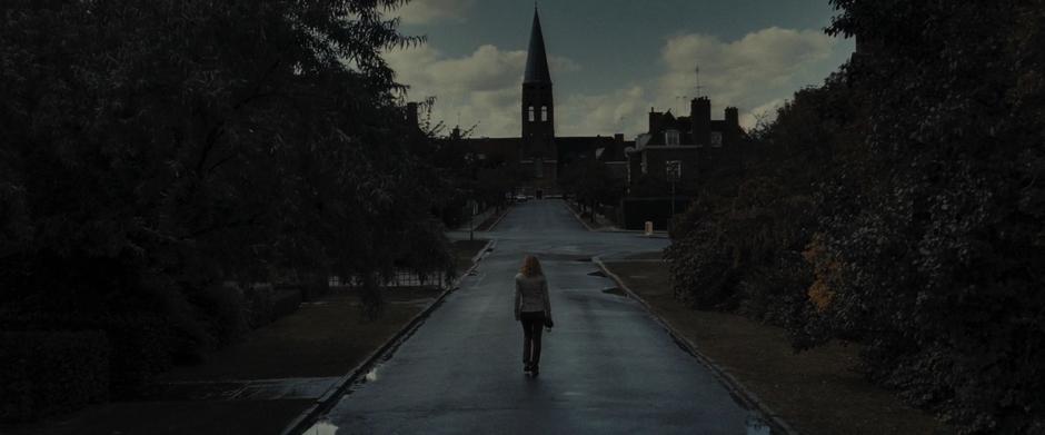 Hermione walks down the street away from her house.