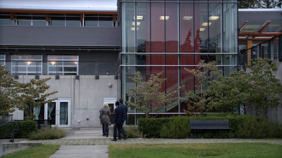 Vivian leads Liv, Major, and Clive into the classroom building on the company campus.