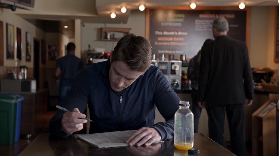 Major looks through the newspaper's classified ads while drinking his OJ.