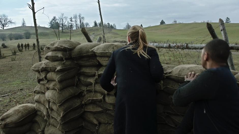 Sara and Jax look over the barricade and see the original version of their team arriving back from the church with Tolkien.