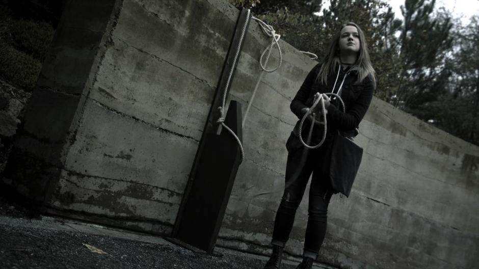 Sylvia ties a rope to a pillar outside the fountain to help her descent into the Poison Room.