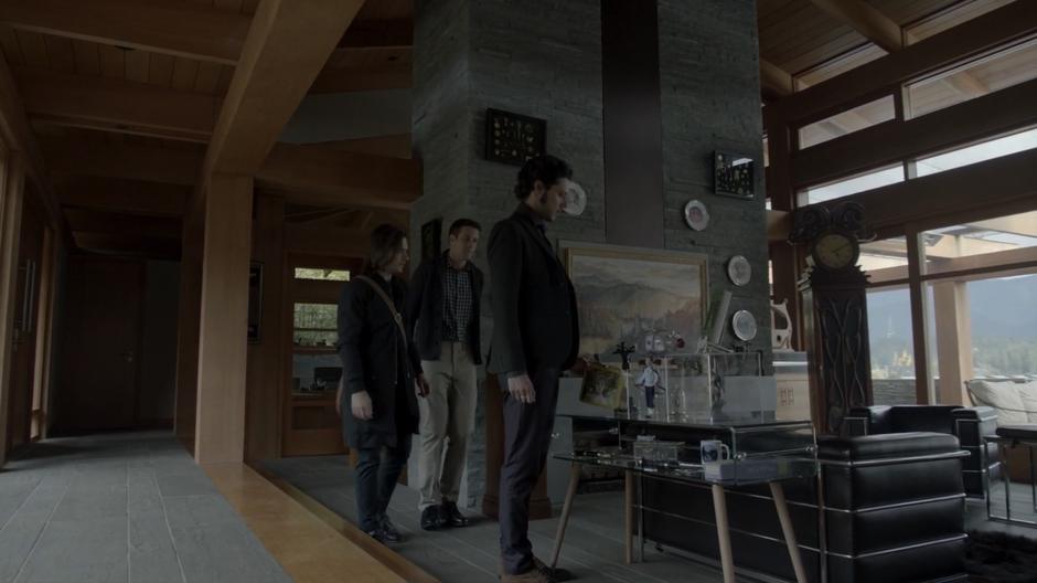 The homeowner shows Eliot and Quentin his collection of Fillory memorabilia in his main room.