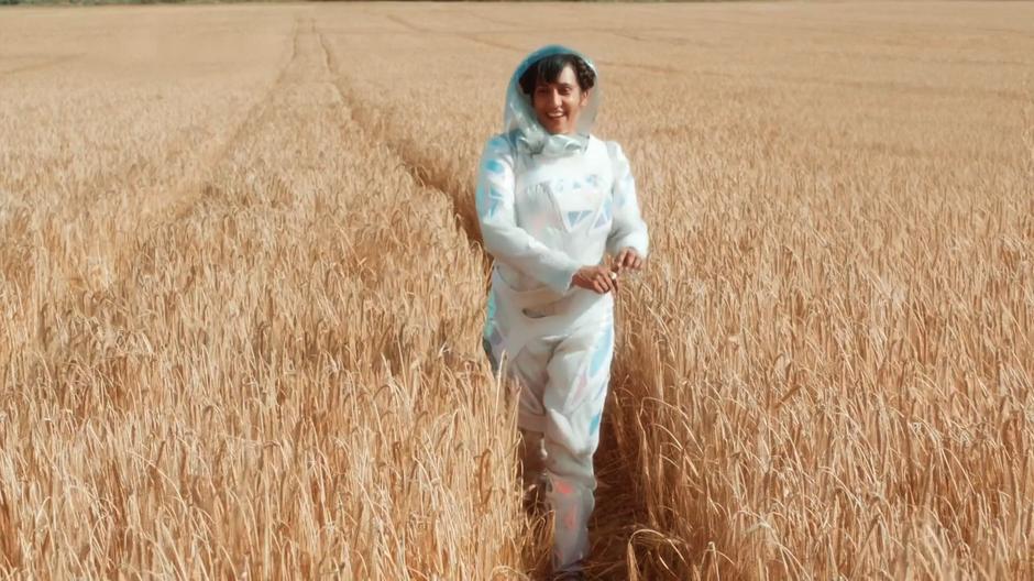 One of the colony's advanced team walks through the wheat field while talking to her colleague back at the city.