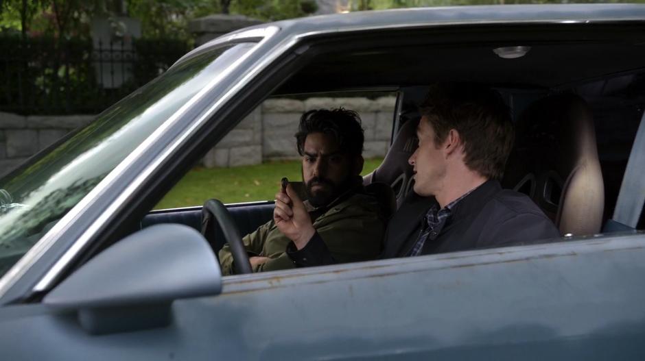 Major shows Ravi the tracker he plans to plant in Osborne Oates's car.