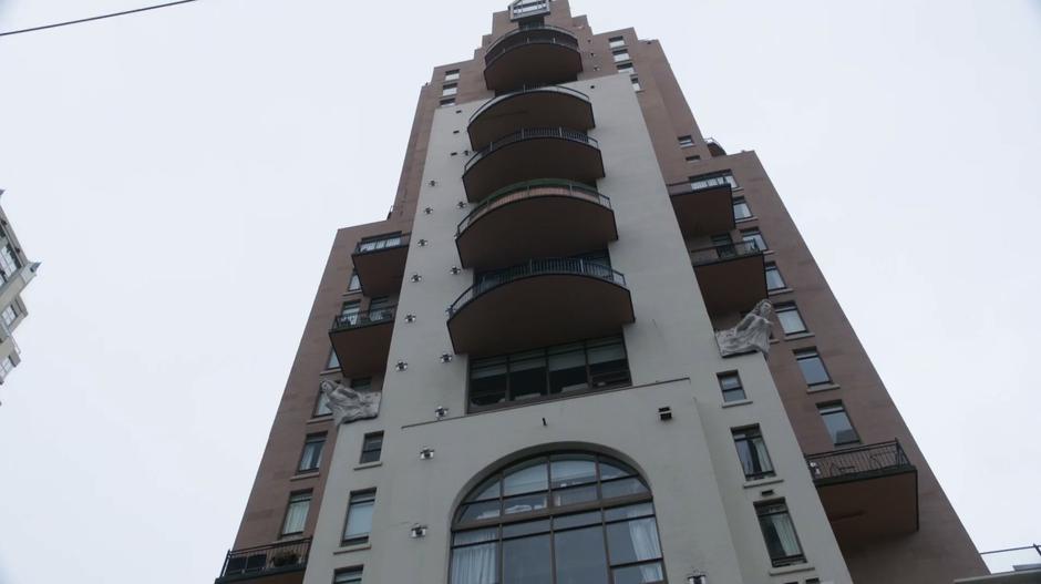 A view looking up at the apartment building from the street.