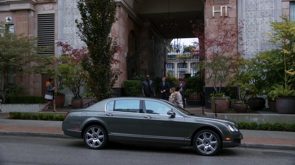 Osborne Oates and his bodyguard walk out to the car parked on the street out front.