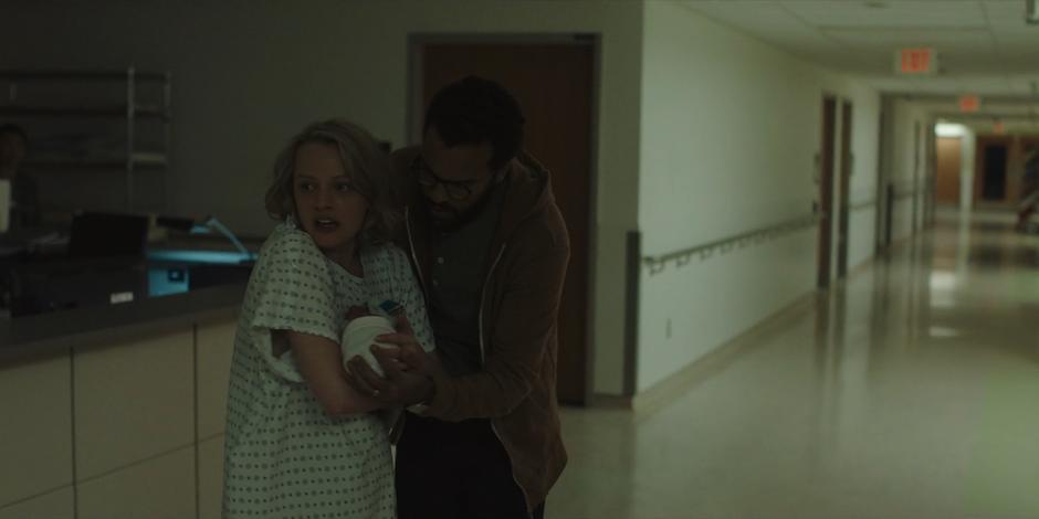 Offred holds Hannah close to her chest and Luke holds her after recovering the baby from the attempted kidnapper.