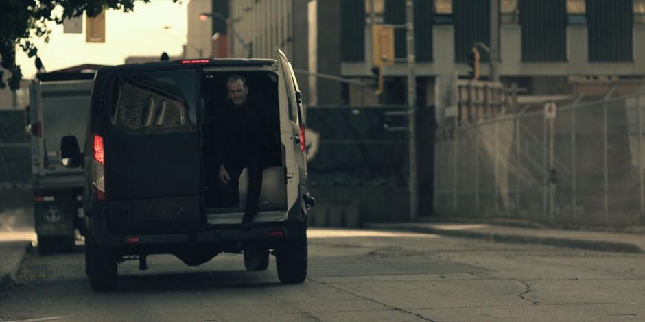 An Eye hops out of the back of one of their black vans.