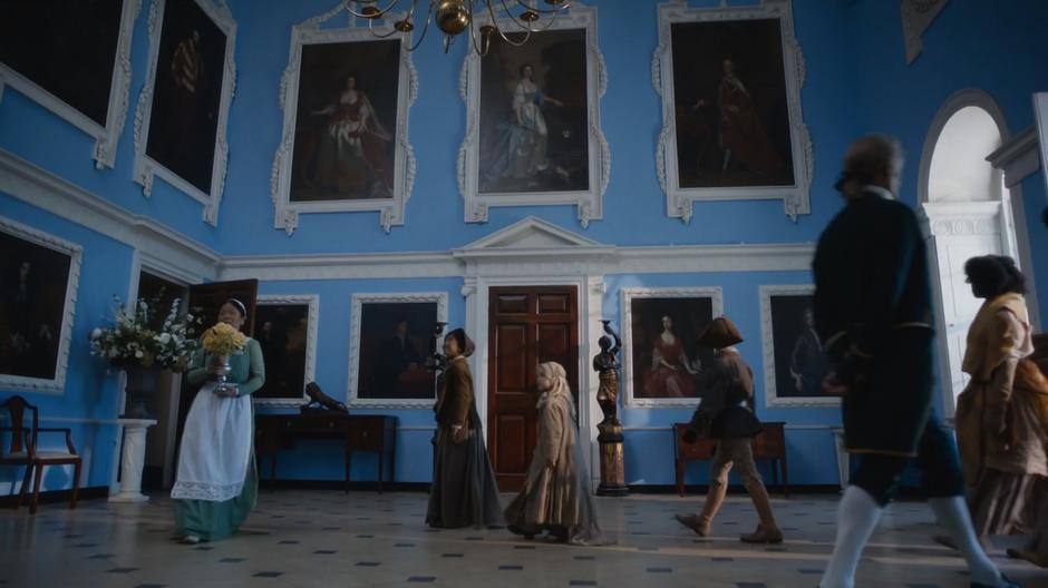 The urchins look around the entry hall in awe as several servants walk past performing their duties.