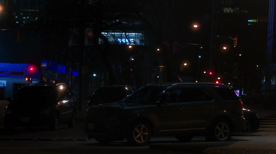 The car sits in a parking spot across the street from the theatre.