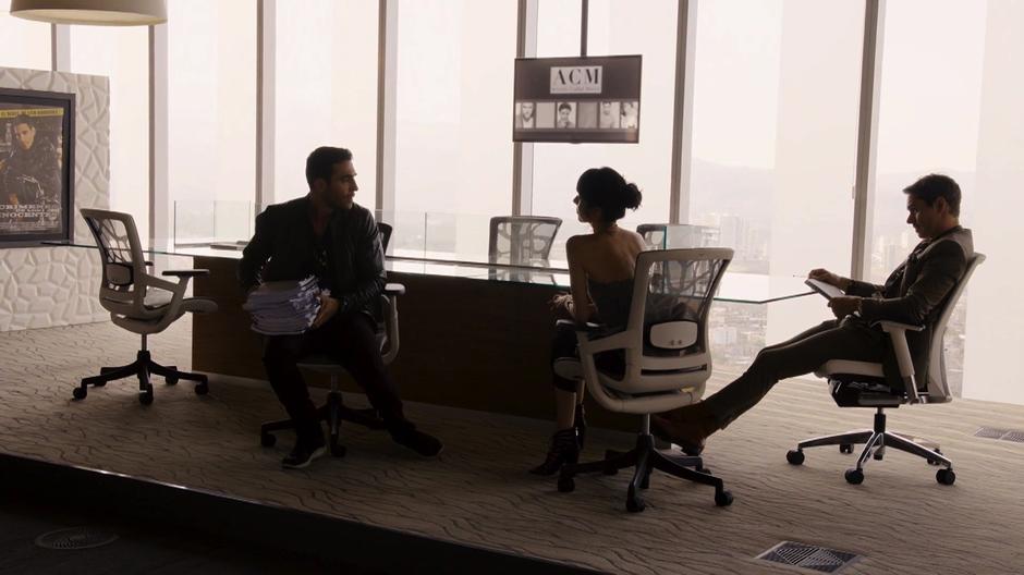 Lito turns away from the desk where his management team is sitting with a big pile of scripts.