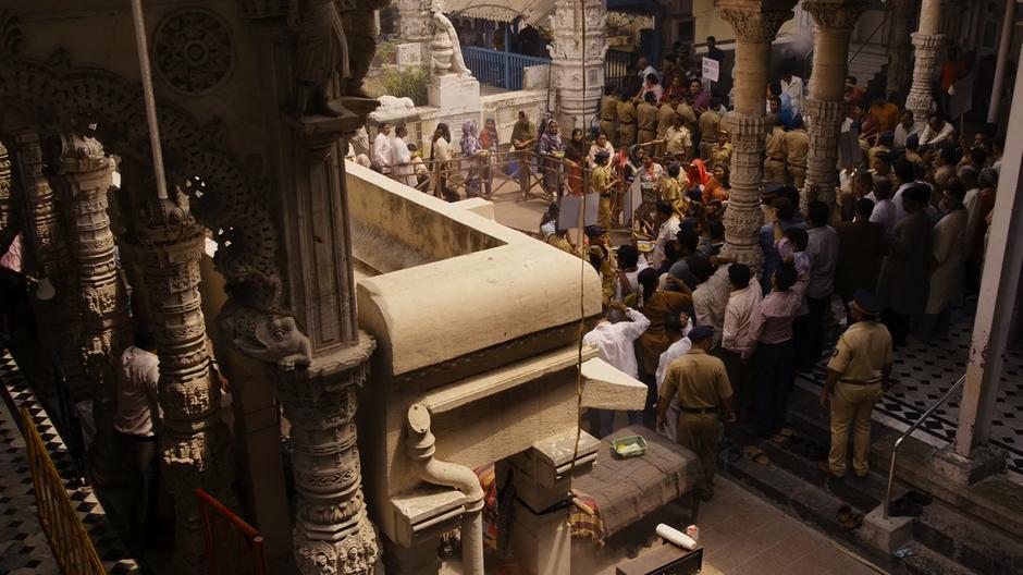 People line up to go through security to get into the temple while protestors surround the courtyard.