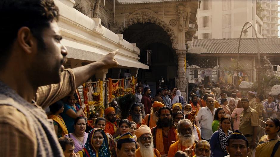 A man points over the crowd while giving a speech to the protestors.